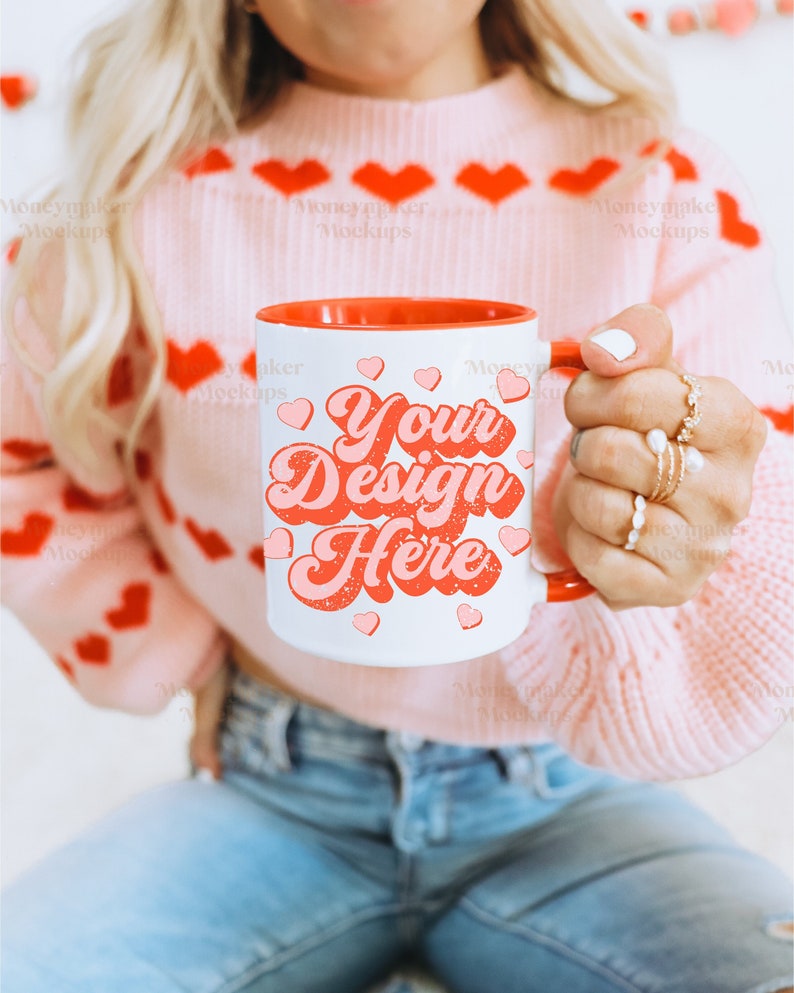 May include: A white ceramic mug with a red rim and handle. The mug features a pink and red design with the text "Your Design Here".