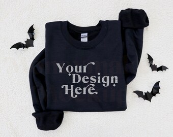 May include: Black sweatshirt with the text "Your Design Here" in a silver glitter font on a white fluffy background. There are four black bats on the background.