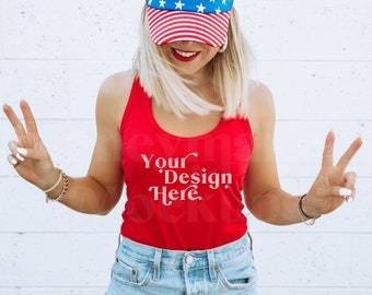 Könnte beinhalten: Eine Frau trägt ein rotes Tanktop mit dem Text "Your Design Here" in Weiß. Sie trägt eine blau-weiße Sternen- und Streifen-Visier und zeigt mit ihren Händen das Peace-Zeichen.