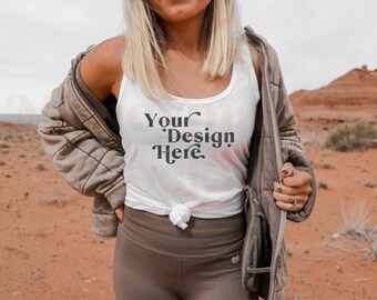 May include: A white tank top with the text "Your Design Here" in a retro font. The tank top is tied at the waist and the model is wearing a brown jacket.