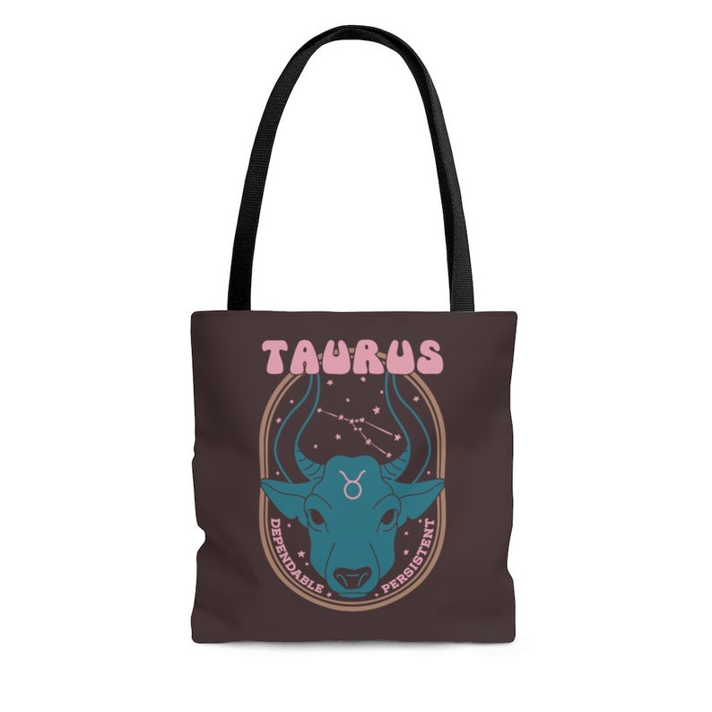 May include: Brown tote bag with black handles featuring a teal bull illustration with the word "TAURUS" in pink. The design includes the Taurus constellation and the words "Dependable" and "Persistent".