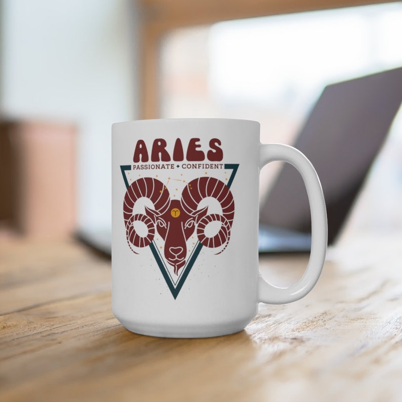 May include: White ceramic mug with a red and brown illustration of an Aries zodiac sign with the text "Aries - Passionate - Confident" in a triangle.
