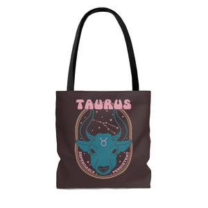 May include: A brown tote bag with black handles featuring a teal bull graphic and the word "TAURUS" in pink. The design includes the Taurus constellation and the words "Dependable" and "Persistent".