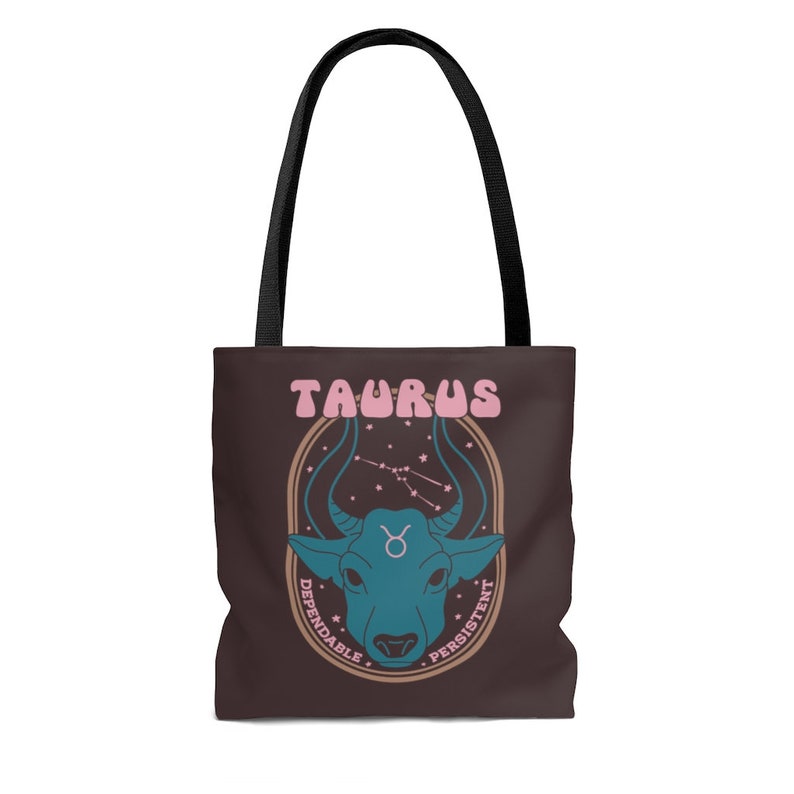 May include: A brown tote bag with black handles featuring a teal bull graphic and the word "TAURUS" in pink. The design includes the Taurus constellation and the words "Dependable" and "Persistent".