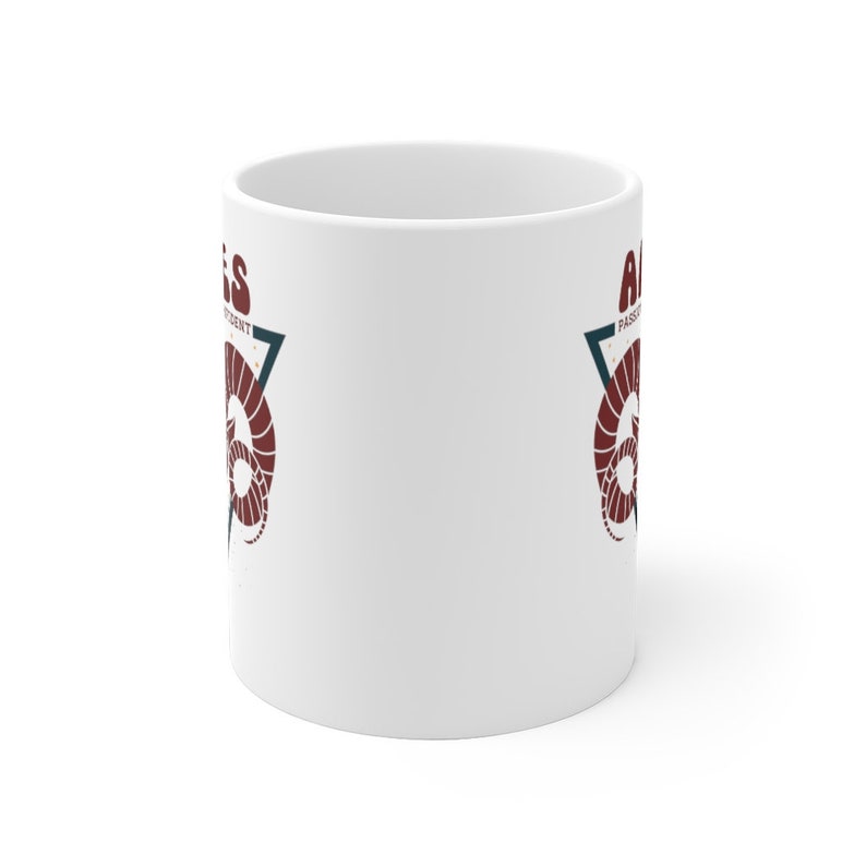 May include: White ceramic mug with a red and blue graphic of a ram's head inside a triangle. The text "Aries" is on the left side of the triangle and "Passionate & Independent" is on the right side of the triangle.