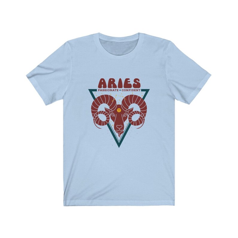 May include: Light blue t-shirt with a red and white graphic of an Aries zodiac sign. The graphic includes the text "Aries" and "Passionate + Confident".