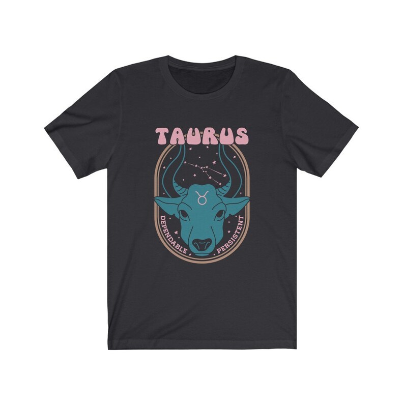 K&ouml;nnte beinhalten: Schwarzes T-Shirt mit einem Grafikdruck eines blauen Bullenkopfes vor einem Hintergrund aus Sternenbildern. Der Text "Taurus" befindet sich &uuml;ber dem Bullenkopf und die W&ouml;rter "Dependable" und "Persistent" sind um den Bullenkopf herum geschrieben.