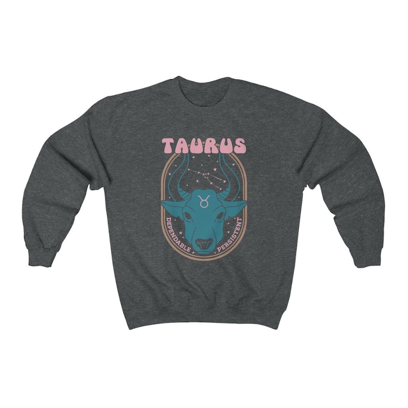 May include: A dark gray sweatshirt with a graphic of a blue bull's head with a pink Taurus sign and the words "Dependable" and "Persistent" in a circle around the bull's head.