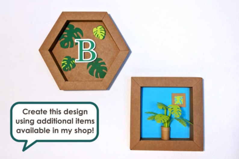 May include: Two framed paper crafts with a tropical theme. The first frame is a hexagon shape with a green letter "B" and green monstera leaves. The second frame is a square with a blue background and a green monstera plant in a brown pot.