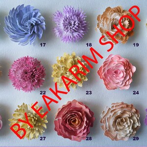May include: Thirty paper flowers in various colors and styles, including roses, carnations, and other floral designs. The flowers are arranged in rows on a light blue background.