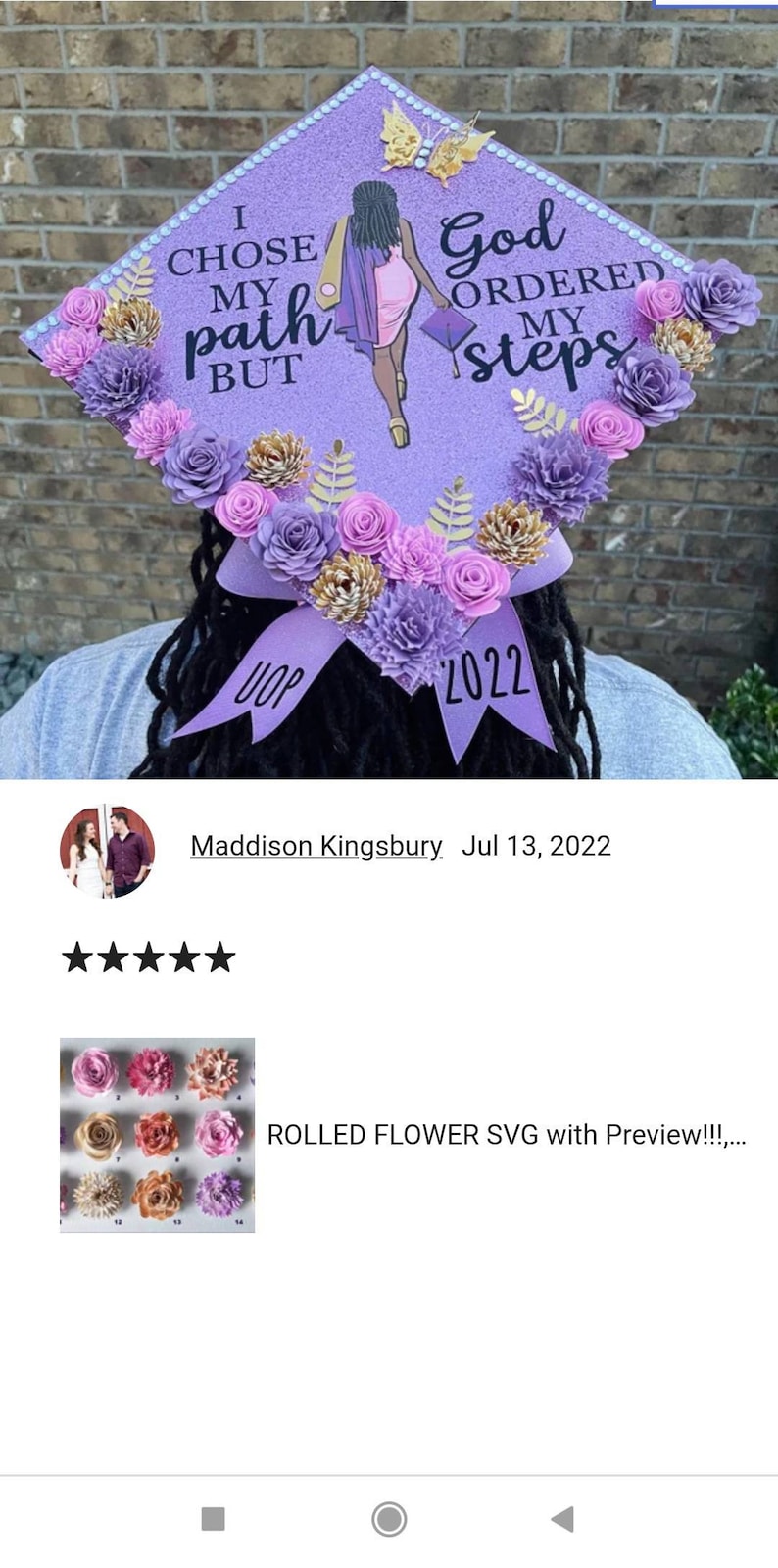 May include: Purple graduation cap decorated with paper flowers in shades of pink, purple, and gold. The cap has the text "I chose my path but God ordered my steps" and "UOP 2022".