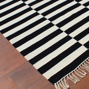 Add a sleek and modern touch to your home with this striped wool rug, handwoven with pure natural wool. The black and white striped design makes it a striking yet timeless piece for living rooms, bedrooms, and hallways. Crafted for durability and style, this rug blends seamlessly into minimalist, Scandinavian, and farmhouse interiors, offering both warmth and elegance.