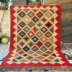 Add a bold statement to your space with this Red Southwestern Rug, a beautifully handcrafted flatweave area carpet inspired by vintage Moroccan and Navajo designs. Featuring rich red hues and intricate geometric motifs