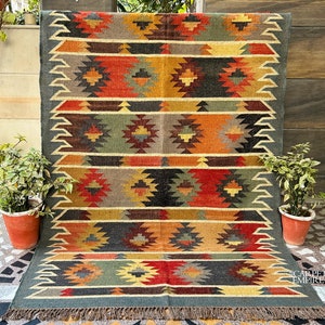 Può includere: Un tappeto colorato con motivo geometrico e bordo a frangia. Il tappeto presenta sfumature di rosso, arancione, giallo, verde, blu e nero. Il tappeto è in lana ed è perfetto per aggiungere un tocco di stile bohémien a qualsiasi stanza.