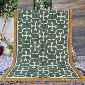 This exquisite handmade flatweave dhurrie combines traditional Navajo patterns with the timeless beauty of Southwestern design, perfect for those who appreciate authentic and vibrant home decor.