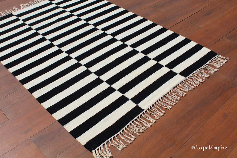Add a sleek and modern touch to your home with this striped wool rug, handwoven with pure natural wool. The black and white striped design makes it a striking yet timeless piece for living rooms, bedrooms, and hallways. Crafted for durability and style, this rug blends seamlessly into minimalist, Scandinavian, and farmhouse interiors, offering both warmth and elegance.