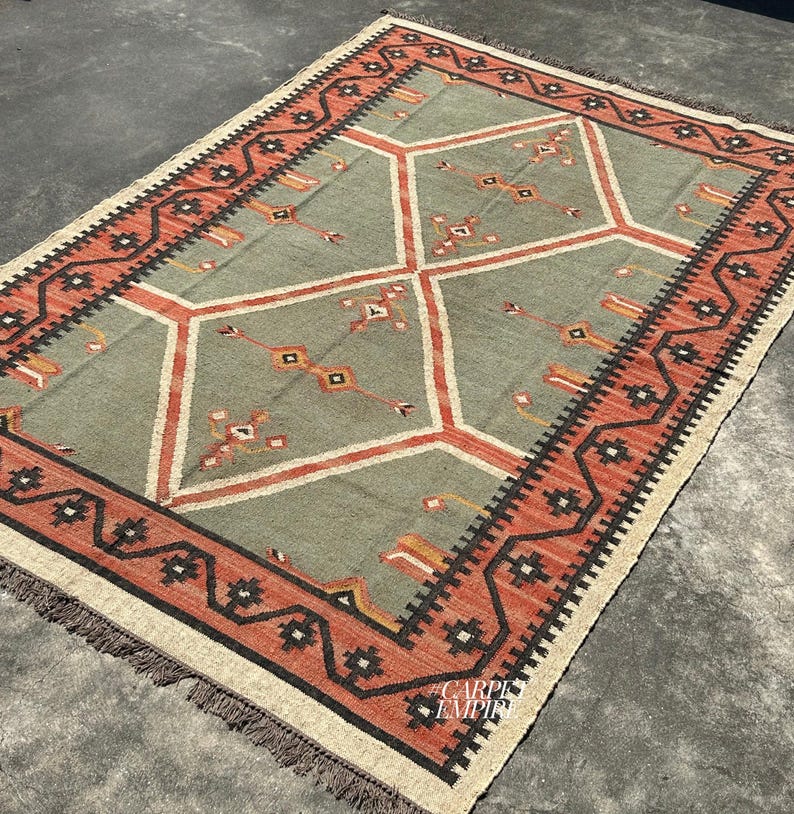 Green and terracotta Moroccan kilim rug with diamond medallions tribal compass motifs and comb tooth border details. Handwoven wool jute flatweave. Custom area rug sizes.