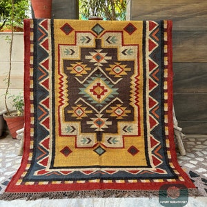 May include: A colorful, geometric patterned rug with a yellow background, red, blue, and brown accents. The rug has a fringe border and is made of wool.