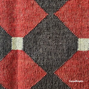 Geometric handwoven kilim rug crafted in red, mustard, and brown hues using traditional wool and jute fibers. Inspired by vintage Navajo and Southwestern rugs, this dhurrie is flatwoven and reversible, ideal for decorating rustic cabins, cozy farmhouses, or contemporary apartments with artisanal character.