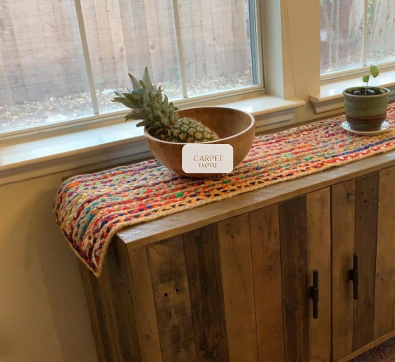 Handmade jute and multicolor cotton table runner with rainbow striped design for boho or farmhouse decor

Eco-friendly table runner made with recycled chindi fabric and jute, ideal for dining tables or kitchen setups

Multicolored Mexican-inspired table runner with handwoven texture and rustic jute weave

Bohemian