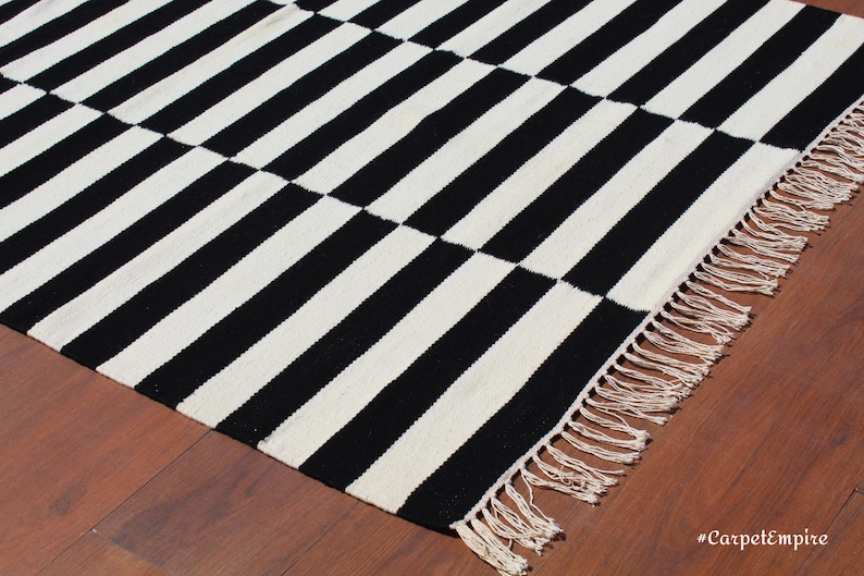 This handwoven wool rug blends traditional craftsmanship with modern aesthetics, making it a timeless choice for any decor style. The striped design offers a sleek, structured look, perfect for monochrome lovers. Whether you need a statement piece for your living room or a functional runner for high-traffic areas, this versatile wool rug delivers both beauty and durability.
