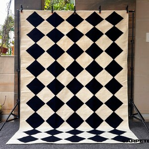 Its clean geometric lines and neutral palette effortlessly complement modern, Japandi, and Nordic interiors, creating a statement of understated elegance.

Each piece is woven by skilled artisans using traditional looms, ensuring every rug carries a unique handmade character. Ideal for living rooms, bedrooms, or open studio spaces, this modern flatweave rug adds texture, warmth, and sophistication while remaining easy to maintain.