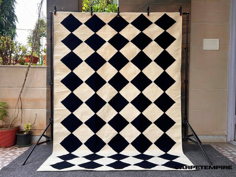 Its clean geometric lines and neutral palette effortlessly complement modern, Japandi, and Nordic interiors, creating a statement of understated elegance.

Each piece is woven by skilled artisans using traditional looms, ensuring every rug carries a unique handmade character. Ideal for living rooms, bedrooms, or open studio spaces, this modern flatweave rug adds texture, warmth, and sophistication while remaining easy to maintain.