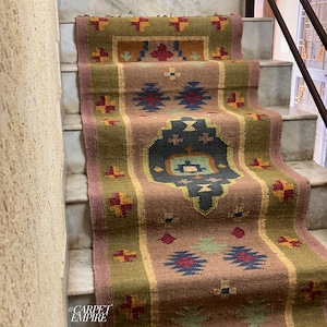 May include: A brown, green, red, and blue patterned rug with a geometric design. The rug is laid out on a set of stairs. The text #CARPETEMPIRE is visible in the bottom left corner of the image.