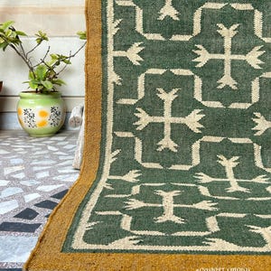 Crafted from high-quality jute, this rug embodies the artisanal skills of Indian and Peruvian weaving traditions. Its natural green hues make it an ideal piece to bring a touch of nature indoors, seamlessly complementing both and rustic interiors.