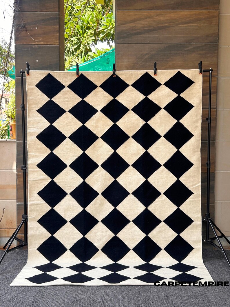 Elegant wool area rug with black and white checkered design, handwoven by artisans using traditional flatweave methods. The 100% wool fiber provides natural softness and durability, making it a perfect fit for Scandi, Japandi, or minimalist home styles.