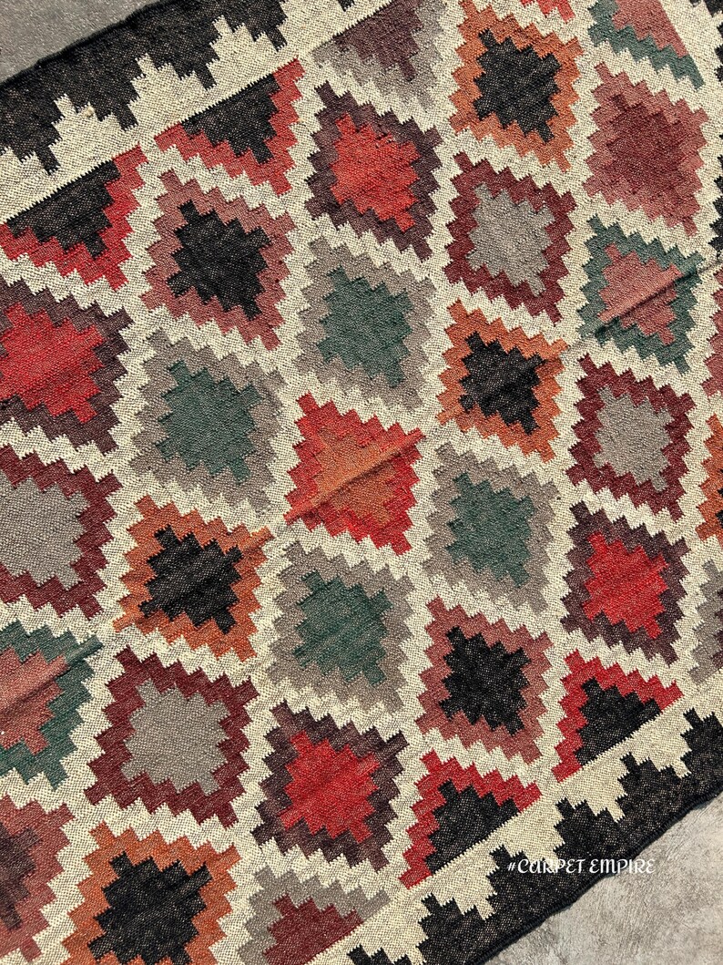 Southwestern-inspired Kilim Area Rug handloomed from jute and wool — earthy multicolor design for boho, tribal, and eclectic homes.
