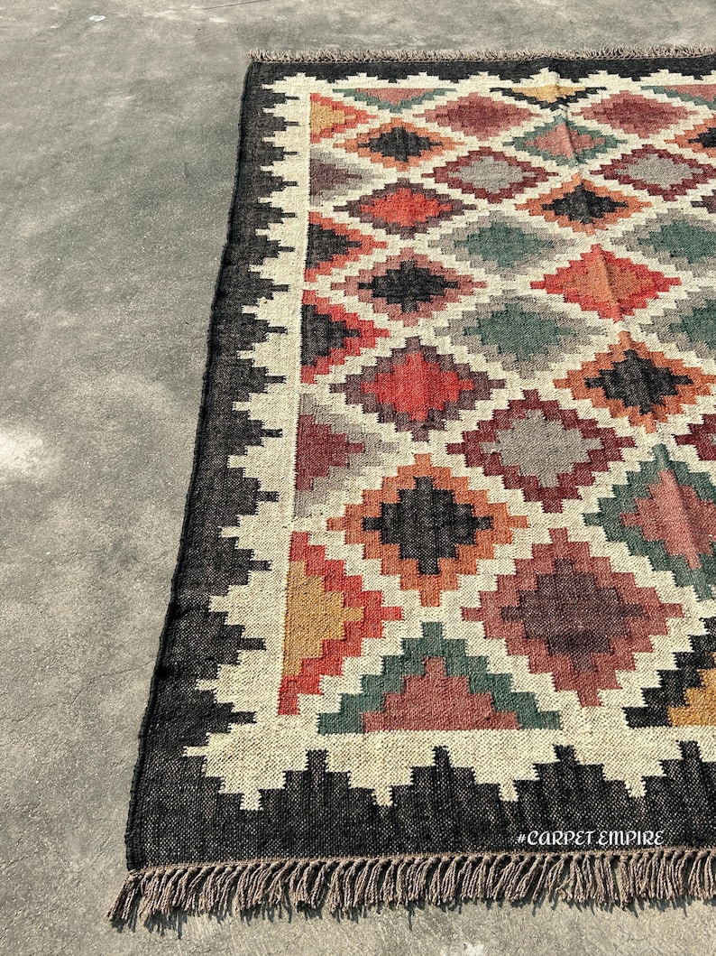 Jute Wool Rug in handwoven kilim weave featuring warm earth tones and black stepped border — a Kilim Area Rug for farmhouse and Mediterranean interiors.