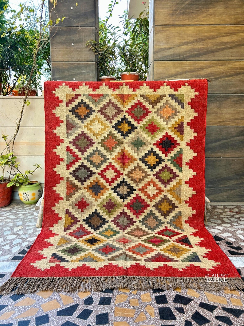 Add a bold statement to your space with this Red Southwestern Rug, a beautifully handcrafted flatweave area carpet inspired by vintage Moroccan and Navajo designs. Featuring rich red hues and intricate geometric motifs