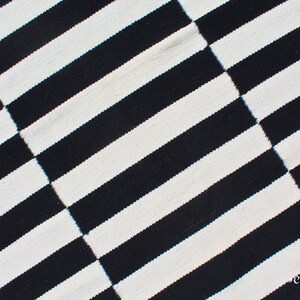 Designed for versatility and style, this monochrome striped rug is a stunning addition to rustic, Scandinavian, and industrial interiors. The bold black and white stripes create a visually striking contrast, while the handcrafted wool weave ensures longevity. Its custom size options allow it to fit hallways, foyers, or under furniture, enhancing any space with elegant simplicity.