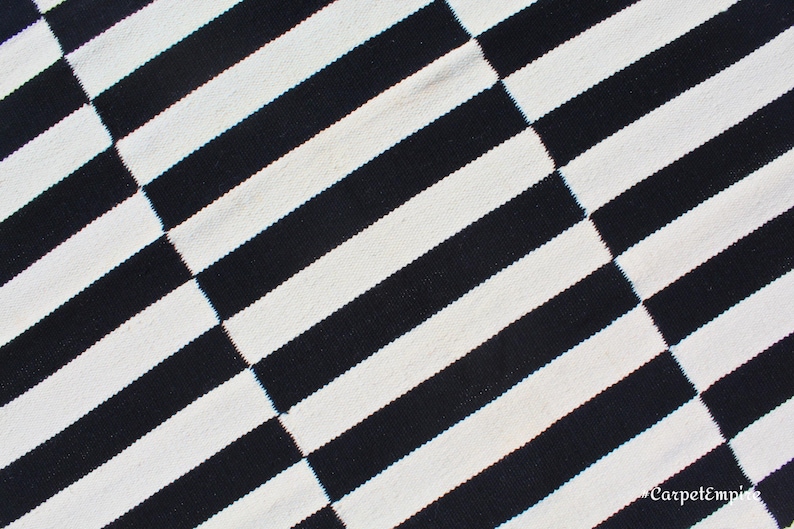 Designed for versatility and style, this monochrome striped rug is a stunning addition to rustic, Scandinavian, and industrial interiors. The bold black and white stripes create a visually striking contrast, while the handcrafted wool weave ensures longevity. Its custom size options allow it to fit hallways, foyers, or under furniture, enhancing any space with elegant simplicity.