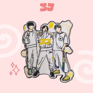 Puede incluir: Un pin de esmalte blanco con una ilustración de dibujos animados de tres personas de pie juntas. Las personas visten ropa informal y tienen acentos amarillos. El pin tiene un fondo blanco con estrellas amarillas y una franja arcoíris.