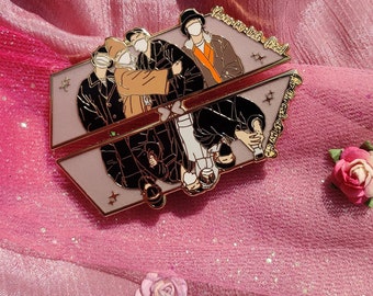 May include: Gold-toned enamel pin featuring a group of five people wearing face masks. The pin is shaped like a split rectangle with the text "You're My Best Friend" on the top half and "Always Remember That" on the bottom half.