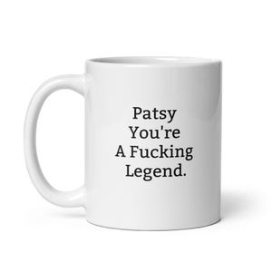 May include: White ceramic coffee mug with black text that reads "Patsy You're A Fucking Legend."