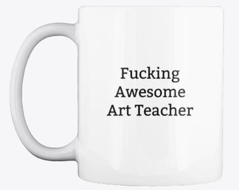 May include: White ceramic coffee mug with black text that reads "Fucking Awesome Art Teacher".