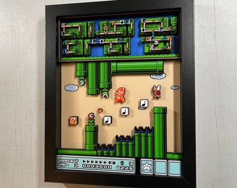 May include: A framed 3D pixel art of a level from the Super Mario Bros. video game. The level features a green pipe, a flower, and a character from the game. The frame is black and the art is in a retro 8-bit style. The text on the bottom of the frame reads "WORLD 7 IM 3 0003000 P 226".