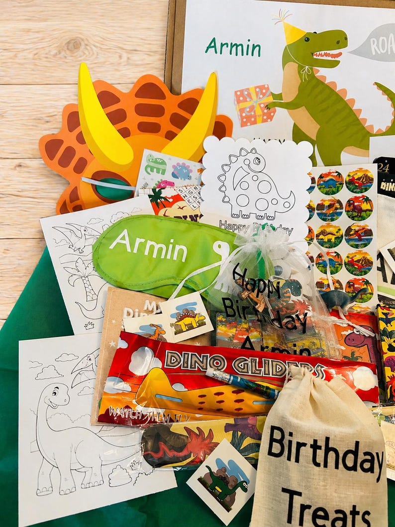 May include: A collection of dinosaur-themed party favors and treats. Includes a dinosaur mask, coloring pages, stickers, a sleep mask with the name "Armin", and a bag labeled "Birthday Treats". The color palette is bright and playful.