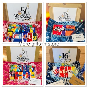 May include: Four open cardboard gift boxes containing assorted candy bars with custom wrappers. The boxes feature printed birthday messages for ages 16, 18, 21, and 50, decorated with party hats and cupcakes. Each box includes colorful shredded paper filler.