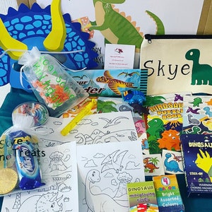 May include: A dinosaur-themed gift box with various items. Includes a canvas bag and a sign with the name "Skye", coloring pages, a puzzle book, crayons, and small toys. The box also contains candy and a gold coin.