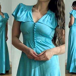 May include: A light blue maxi dress with a V-neckline and short, ruffled sleeves. The dress features a row of buttons down the front and a cinched waist. The dress is floor-length and has a flowing skirt.