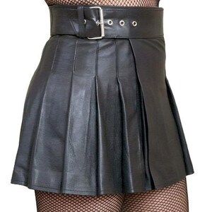 May include: A black leather mini skirt with pleats and a wide black belt with a silver buckle. The skirt is worn with black fishnet tights.