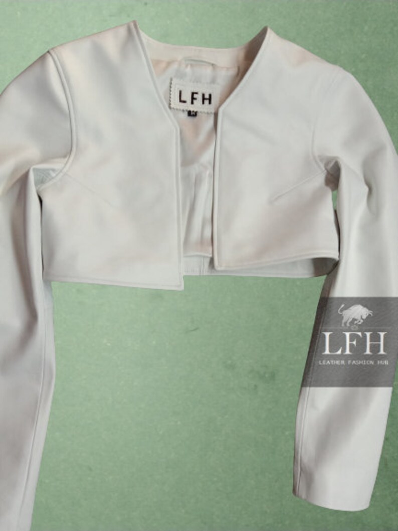 May include: A white cropped leather jacket with long sleeves. The jacket has a V-neck and a label that says "LFH" on the front.