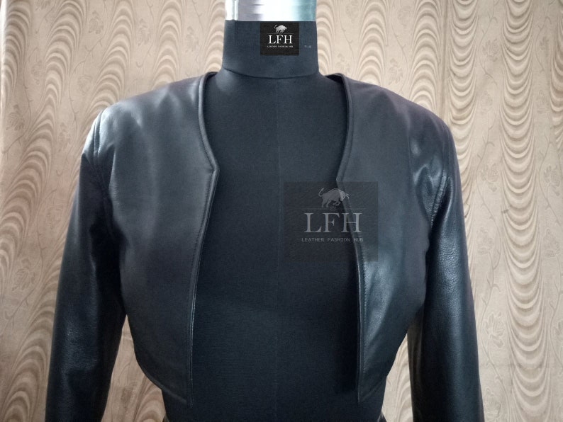 May include: A black leather cropped jacket with long sleeves. The jacket has a V-neck and a simple design. The label "LFH Leather Fashion Hub" is visible on the front.