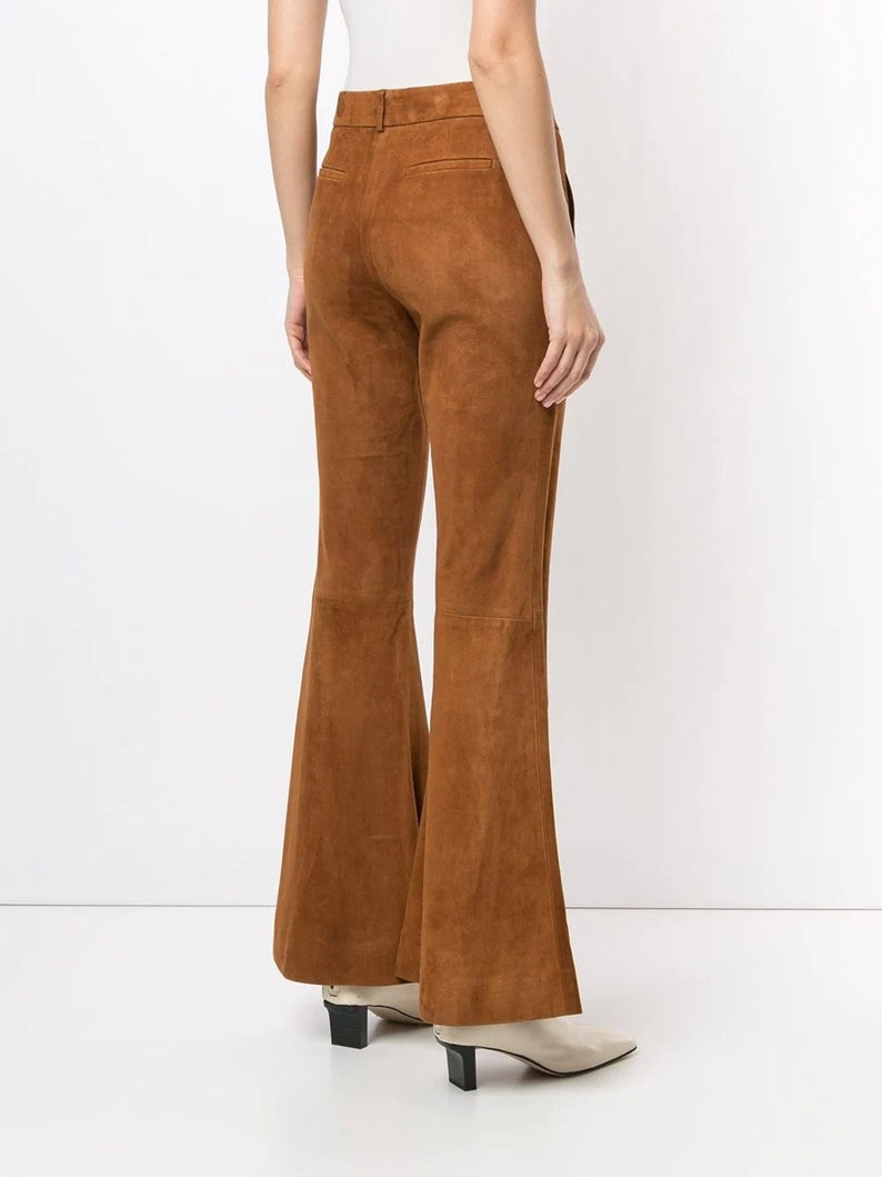 Pode incluir: Cal&ccedil;a flare marrom de camur&ccedil;a com cintura alta e corte reto.