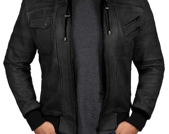 May include: A black leather jacket with a hooded collar and zipper closure. The jacket has a zippered pocket on the left chest and two zippered pockets on the lower front. The jacket has a ribbed knit cuff and hem.