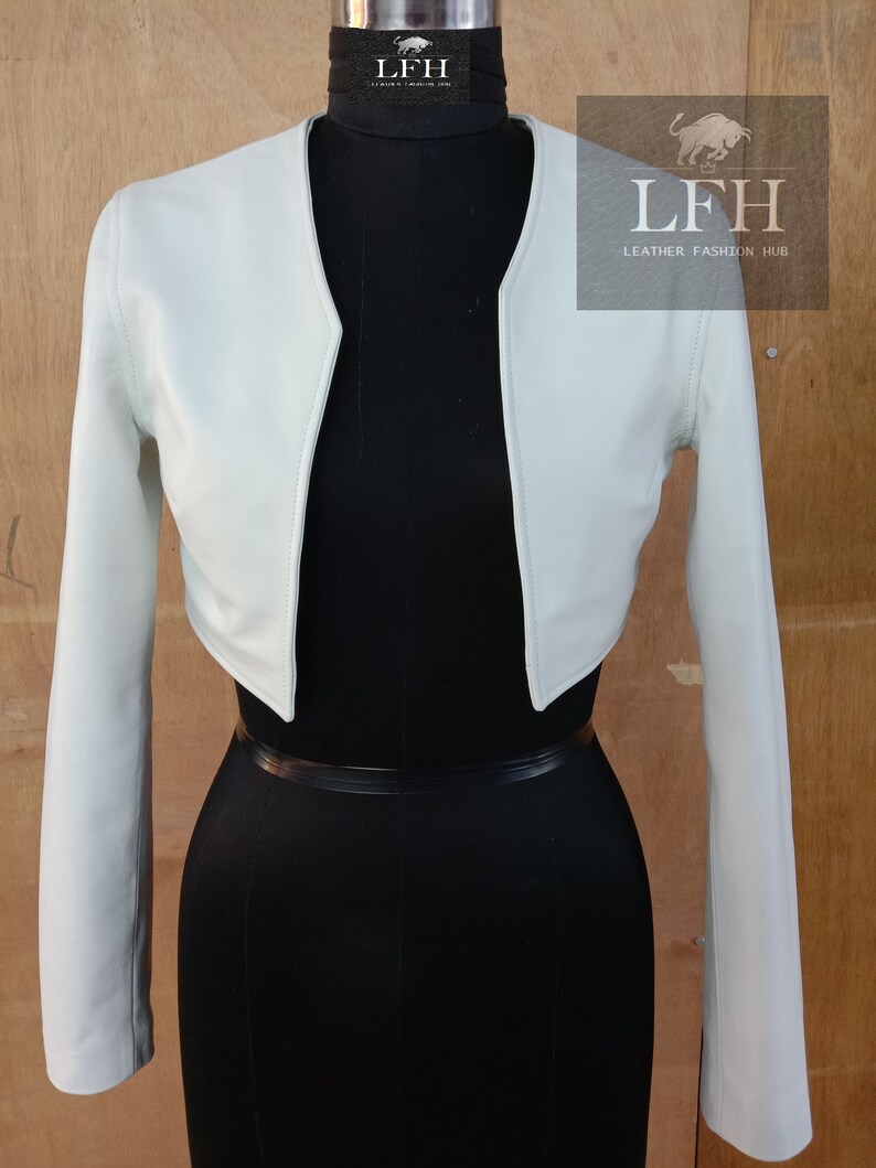 May include: A light green cropped leather jacket with long sleeves. The jacket has a V-neck and is shown on a mannequin. The text "LFH Leather Fashion Hub" is visible on the image.